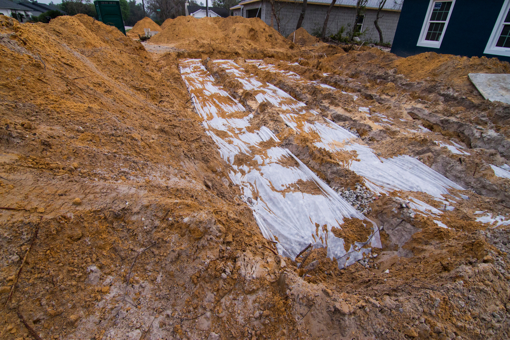 Covered trenches in a septic drain field under construction.